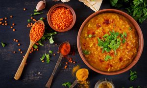 bowl of red lentil and squash soup with an assortment of spices