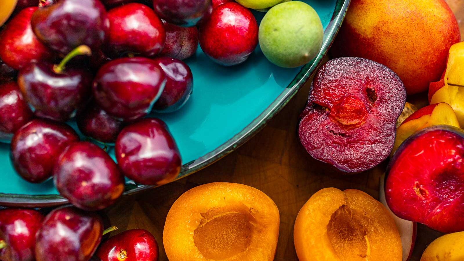 Close up view of stone fruit on a cutting board and plate