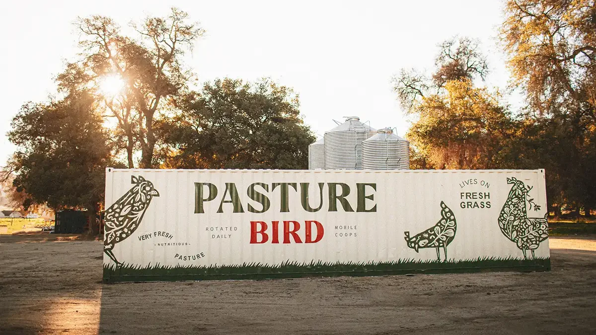 A sign for Pasturebird painted on a shipping container.