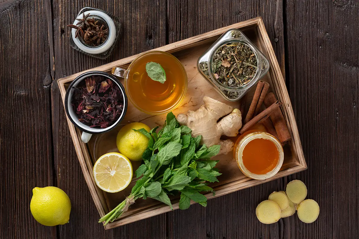 A collection of herbs and spices in a wooden tray.