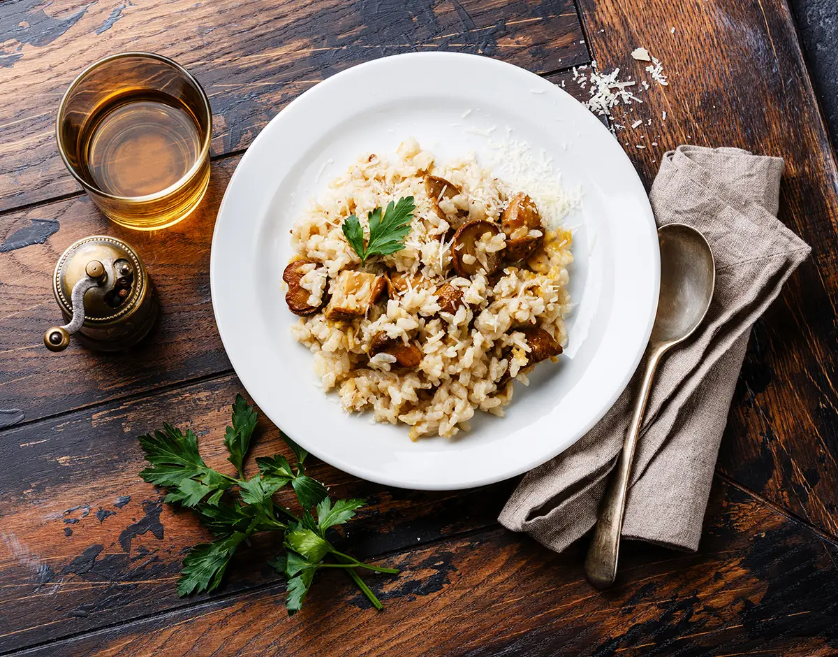Mushroom-Risotto Risotto with porcini mushroom on wooden table